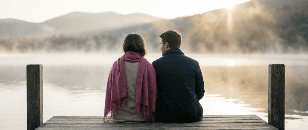 Rester ou partir : Couple de dos sur un quai au bord de l'eau, brume matinale qui se lève