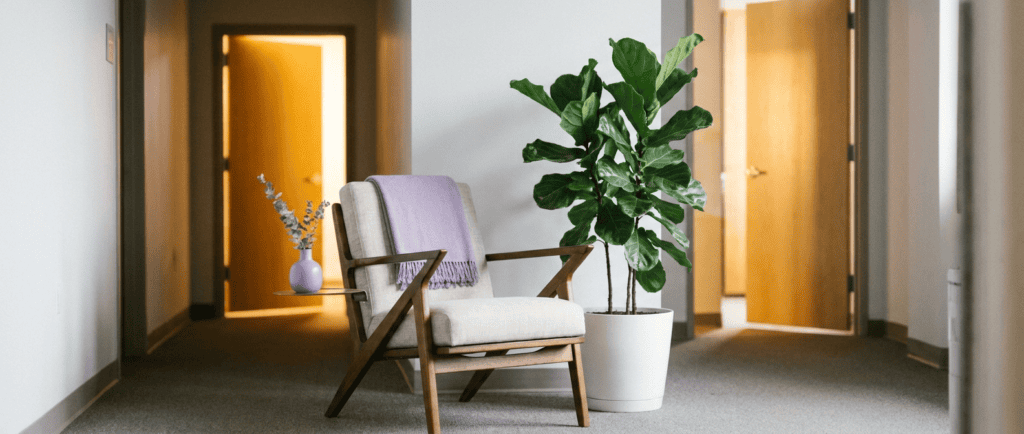Entretien d'embauche : Chaise dans un couloir d'attente, porte entrouverte laissant passer une lumière chaude